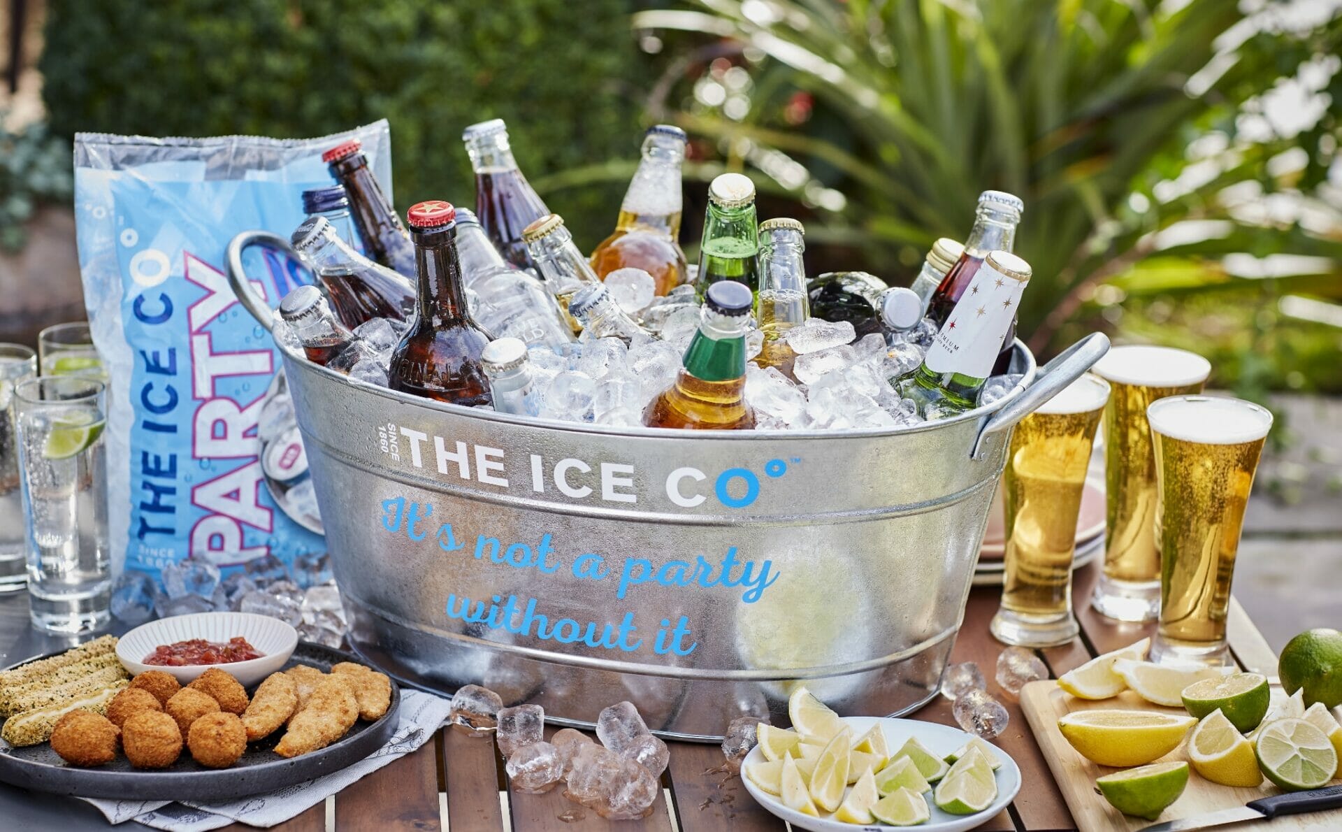 A large ice bucket filled with Party Ice cubes and bottled drinks.
