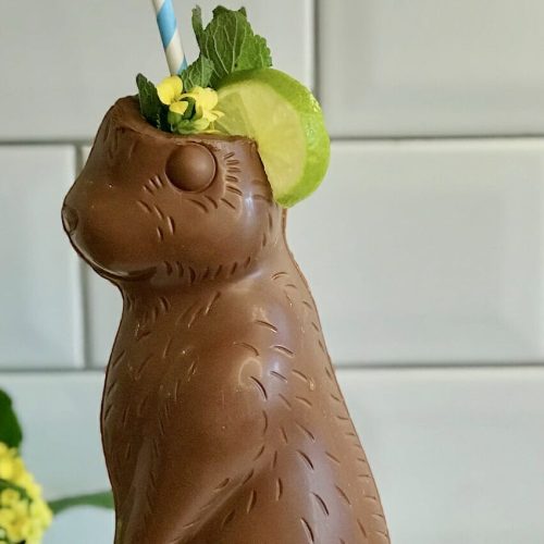 A cocktail that has been served in a chocolate easter bunny, served over crushed ice.