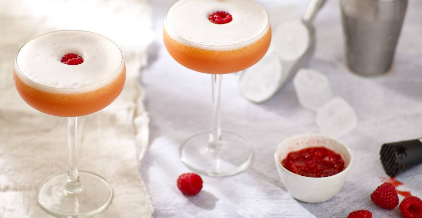 Two raspberry cocktails on a table