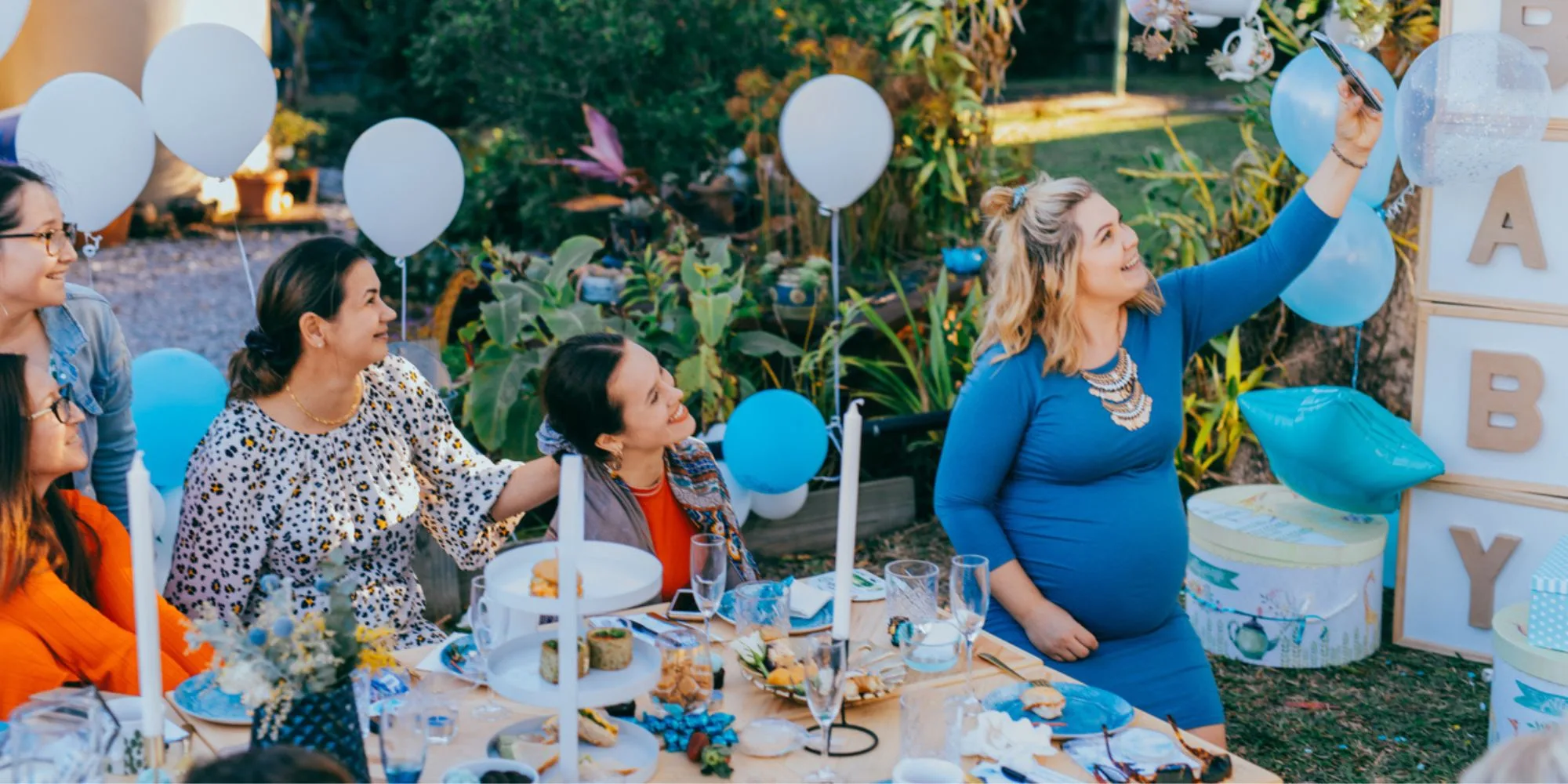 Woman celebrates her baby shower in the garden with friends