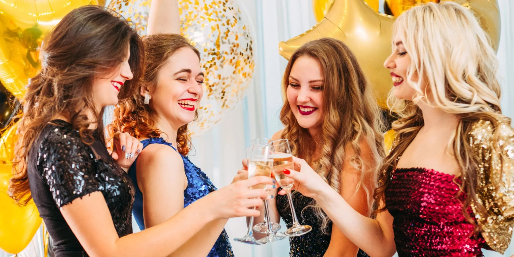 girls clinking hcmpagne glasses celebrating their graduation