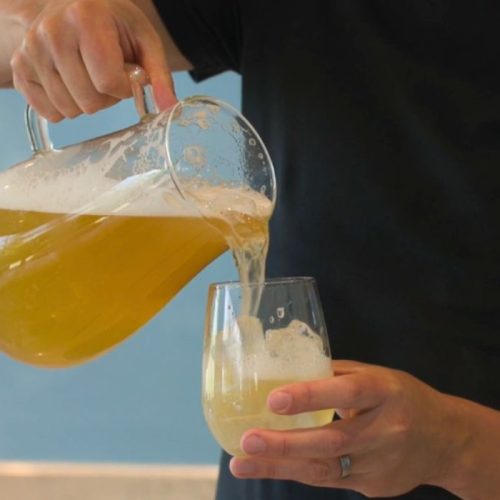 Alcohol Free lemon shandy sangria poured into a glass from a pitcher jug