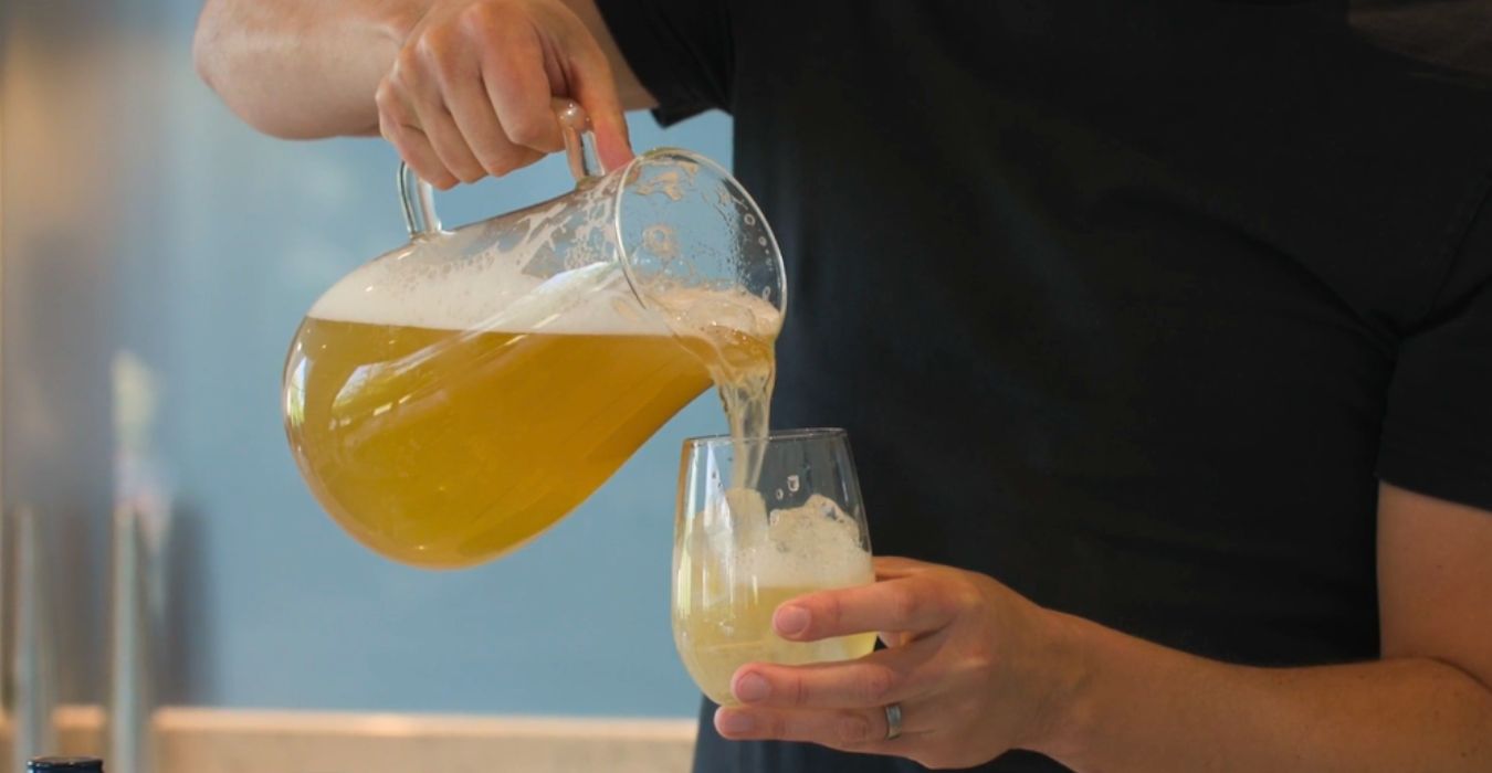 Alcohol Free lemon shandy sangria poured into a glass from a pitcher jug