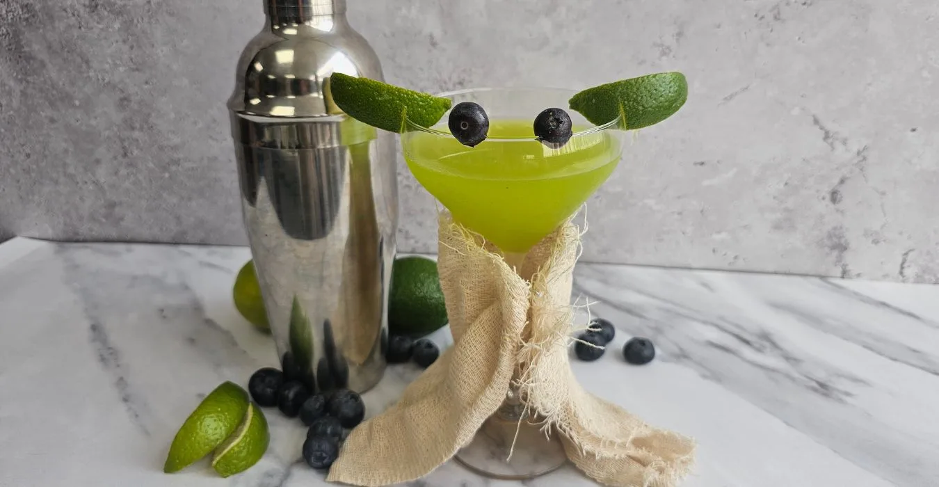Star Wars Day Baby Yoda Cocktail, Green cocktail with lime ears and blueberry eyes