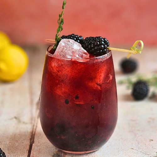 blackberry lemon fizz mocktail with fresh lemons and berries