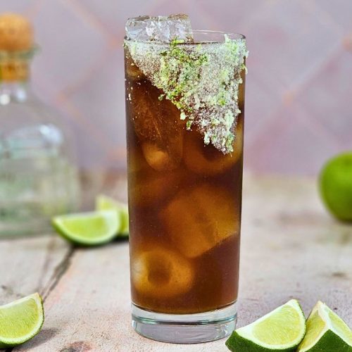 batanga cocktail made with cola next to el patron bottle and fresh limes