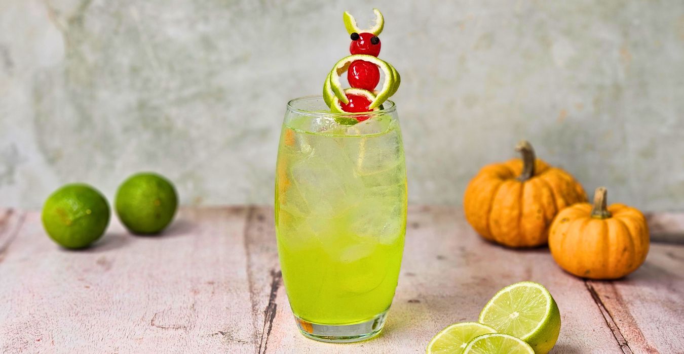 electric tokyo tea cocktail with small pumpkins and sliced lime