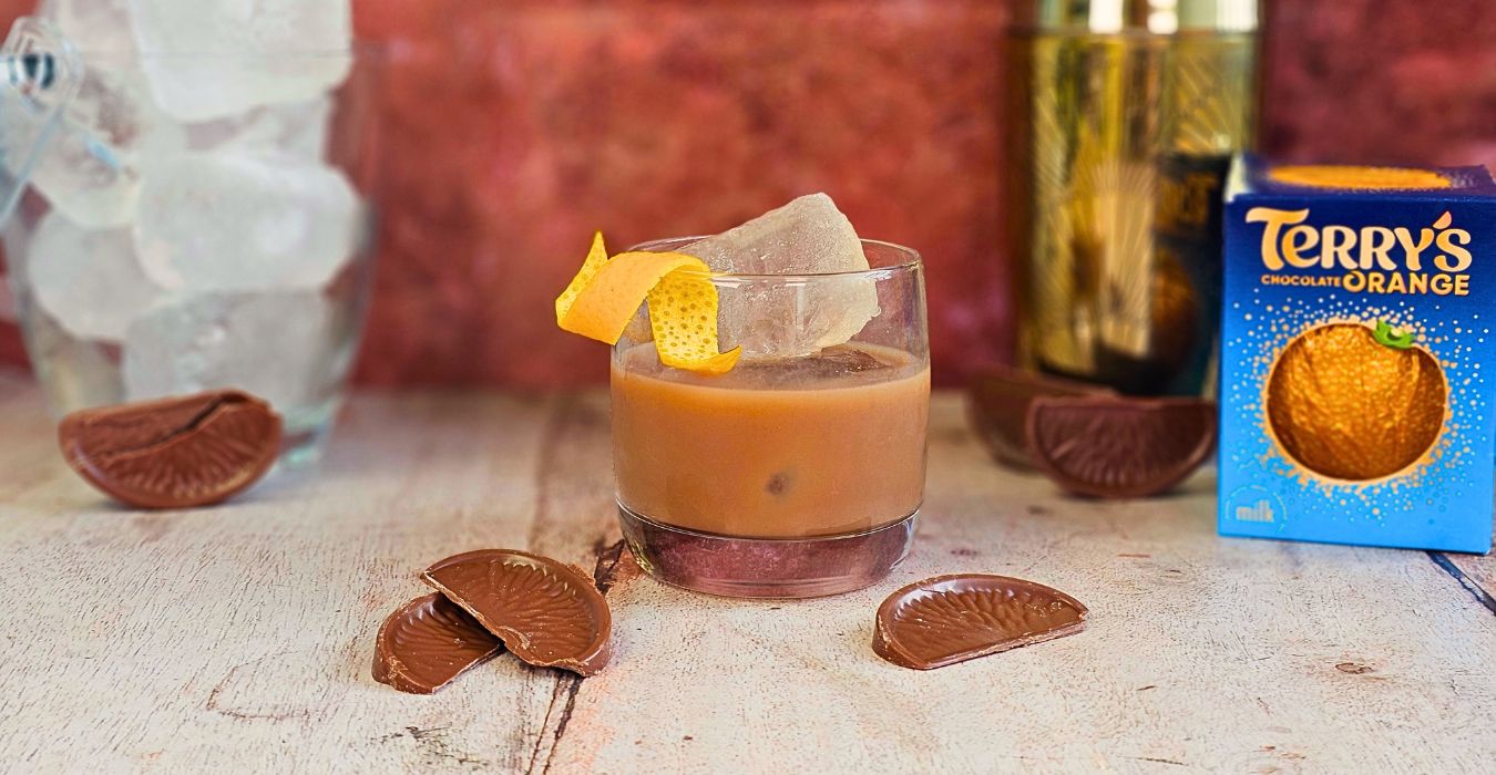 Chocolate Orange Old Fashioned cocktail in a short glass with chocolate orange garnish